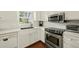 Modern kitchen with white cabinetry, stainless steel appliances, and hardwood floors at 2415 Alpine Rd, Durham, NC 27707
