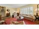 Cozy living room featuring large windows, neutral-toned furniture, and hardwood flooring at 2415 Alpine Rd, Durham, NC 27707