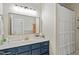 Charming bathroom boasts a navy vanity, modern mirror, and shower with curtain at 2651 Mellow Field Dr # 206, Raleigh, NC 27604