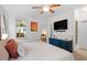 Cozy bedroom boasts a ceiling fan, large window, and view into the living room at 2651 Mellow Field Dr # 206, Raleigh, NC 27604