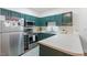 The kitchen features modern appliances, green cabinets, and a white countertop at 2651 Mellow Field Dr # 206, Raleigh, NC 27604