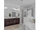 Bathroom featuring double sinks, granite countertop, soaking tub, and glass enclosed shower at 2705 Evanston Ave, Durham, NC 27703