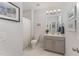 Well-lit bathroom with a gray vanity, framed artwork, and a shower with a patterned curtain at 2832 Thompson Bluff Dr, Cary, NC 27519