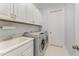 Laundry room features a sink, washer, dryer, white cabinets, and tiled flooring at 2832 Thompson Bluff Dr, Cary, NC 27519