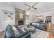 Open-concept living room with a stone fireplace, built-in shelving, and a view into the modern kitchen at 2832 Thompson Bluff Dr, Cary, NC 27519