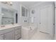Bright main bathroom features a soaking tub with marble surround, double vanity, and glass-enclosed shower at 2832 Thompson Bluff Dr, Cary, NC 27519