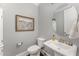 Elegant powder room with a pedestal sink, round mirror, and neutral paint color at 2832 Thompson Bluff Dr, Cary, NC 27519