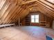 Large unfinished attic space with wood framing and a window providing natural light at 2905 Pluton Pl, Rolesville, NC 27571