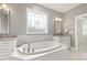 Bright bathroom with a soaking tub, detailed window, and and sink at 2905 Pluton Pl, Rolesville, NC 27571