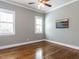 A well-lit bedroom with hardwood floors and neutral colored walls at 2905 Pluton Pl, Rolesville, NC 27571