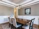 Formal dining room showcasing rich wood floors, wainscoting, and a stylish hanging light fixture at 2905 Pluton Pl, Rolesville, NC 27571