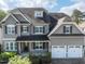 Charming home featuring a two-car garage, stone accents, gray siding, and neatly trimmed landscaping at 2905 Pluton Pl, Rolesville, NC 27571