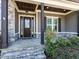 A charming home entrance with stone accents, wood details, and a stone walkway at 2905 Pluton Pl, Rolesville, NC 27571