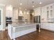Spacious kitchen with a large center island, stainless steel appliances, and pendant lighting at 2905 Pluton Pl, Rolesville, NC 27571