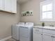 Bright laundry room featuring side-by-side washer and dryer, plus cabinets and sink at 2905 Pluton Pl, Rolesville, NC 27571