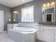 Elegant main bathroom featuring a soaking tub, granite counters, and white cabinets at 2905 Pluton Pl, Rolesville, NC 27571