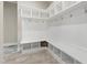 Bright mudroom features white cabinets, cubbies, coat hooks, and bench seating with storage at 2905 Pluton Pl, Rolesville, NC 27571