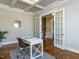 Well-lit office with French doors, a white desk, and a stylish rug on the hardwood floors at 2905 Pluton Pl, Rolesville, NC 27571