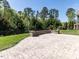 Paver patio with stone seating wall overlooks the backyard at 2905 Pluton Pl, Rolesville, NC 27571