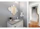Stylish powder room features decorative mirror, granite countertop, and access to the staircase at 2905 Pluton Pl, Rolesville, NC 27571