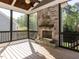 Beautiful screened porch with stone fireplace, ceiling fan, and wood flooring at 2905 Pluton Pl, Rolesville, NC 27571