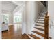 Elegant staircase with wood treads and white risers leads to the upper level and adjoins the living room at 2905 Pluton Pl, Rolesville, NC 27571