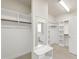Spacious walk-in closet with carpet, and bench seat with view into the bathroom at 2905 Pluton Pl, Rolesville, NC 27571