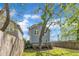 Back exterior view of a blue house with a wooden deck, green grass, and a large tree at 3 Maple St, Raleigh, NC 27610