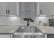 Close up on kitchen sink with window and white subway tile backsplash at 3 Maple St, Raleigh, NC 27610