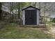 Backyard features storage shed in a wooded lot and partial fence at 300 Round About Rd, Holly Springs, NC 27540
