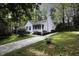 Beautiful home with a well-manicured lawn, mature trees, and inviting front porch at 300 Round About Rd, Holly Springs, NC 27540