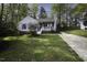 Attractive home with blue shutters and a welcoming front porch, set in a lush green yard at 300 Round About Rd, Holly Springs, NC 27540