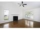 Bright living room features a fireplace, vaulted ceiling with fan and beautiful hardwood floors at 300 Round About Rd, Holly Springs, NC 27540