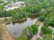 Aerial view showcases a community pond surrounded by lush greenery near buildings and residences at 307 Parkmeadow Dr, Cary, NC 27519