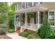 Inviting front porch with white railings, hanging plants, and a wooden front door at 307 Parkmeadow Dr, Cary, NC 27519