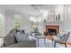 Cozy living room featuring a fireplace with red brick surround, plush seating, and natural light from bright windows at 307 Parkmeadow Dr, Cary, NC 27519