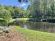 Beautiful community pond with a bridge, lush greenery, and landscaping on a sunny day at 307 Parkmeadow Dr, Cary, NC 27519