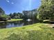 Scenic community pond with a fountain and lush greenery surrounding it on a sunny day at 307 Parkmeadow Dr, Cary, NC 27519