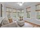 Bright sunroom with a hardwood floor, neutral furnishings, and large windows with wooded views at 307 Parkmeadow Dr, Cary, NC 27519