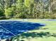 Multiple blue and green tennis courts with nets are surrounded by lush green trees in this community at 307 Parkmeadow Dr, Cary, NC 27519