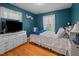 Bright bedroom featuring hardwood floors, a white dresser, and a comfortable bed at 310 Edward Ln, Louisburg, NC 27549