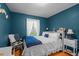 Cozy bedroom with hardwood floors, blue accent walls, and comfortable furnishings at 310 Edward Ln, Louisburg, NC 27549
