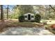 Outdoor shed in a wooded yard, featuring a concrete pad and manicured hedges at 310 Edward Ln, Louisburg, NC 27549