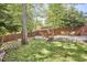 Landscaped backyard with patio seating, a wooden fence, and mature trees at 315 Greenwood Dr, Durham, NC 27704