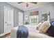 Bedroom features a double bed with blue accent pillows and blanket, wood floor, and stylish woven window shades at 315 Greenwood Dr, Durham, NC 27704