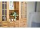 Close-up of the wooden built-in china cabinet, displaying glass doors, shelves, and drawer storage with decor at 315 Greenwood Dr, Durham, NC 27704