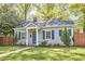 Quaint single-story home with a manicured lawn, complemented by blue shutters and a welcoming facade at 315 Greenwood Dr, Durham, NC 27704