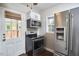 Modern kitchen features stainless steel appliances, white cabinets, and a door leading to the outside area at 315 Greenwood Dr, Durham, NC 27704
