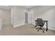 Neutral bedroom with a door to the ensuite bathroom, featuring carpet floors, and a desk with a black chair at 318 Acorn Hollow Pl, Durham, NC 27703