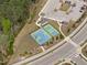 Aerial view of community amenities, including tennis and basketball courts, surrounded by greenery at 3262 Ripley River Rd, New Hill, NC 27562